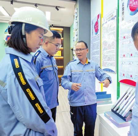 在易门铜业有限公司“中铝技能大师工作室”,陶汝云(右)与工作室成员讨论近期生产问题。